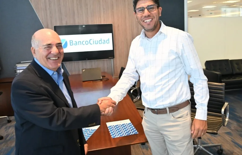 Imagen de la firma del convenio: Gustavo Cardoni, Gerente General del Banco Ciudad, y Maximiliano Cáceres, Gerente Comercial de YCRT.